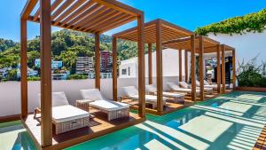 a pool with chairs and a pavilion on top of a building at SOHO PV - 1007 Best and Brand New Condo in Puerto Vallarta