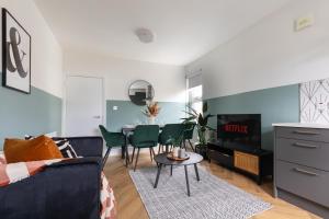 een woonkamer met een bank en een tafel bij Beautiful 3BR Flat with Desks and Fast Wi-Fi in Londen
