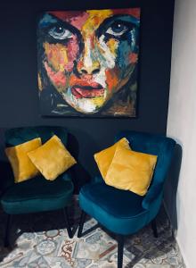 dwa niebieskie krzesła i obraz kobiety w obiekcie Rooms & Apartment ZALA Airport shuttle option w mieście Cerklje na Gorenjskem