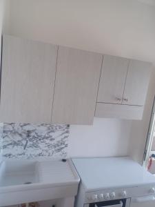 a kitchen with white cabinets and a sink at Perla Marina in San Nicola