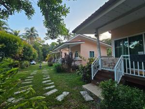 a house with a pathway leading to the front yard at Baan suan khun ta บ้านพักสวนคุณตา in Ko Chang