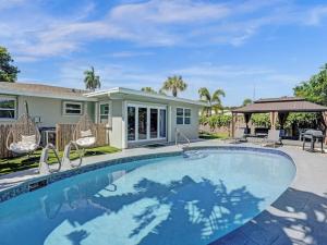 a swimming pool in front of a house at Poolside Paradise Spacious 3BR Haven near Pompano Beach in Pompano Beach