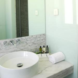 a white bathroom with a sink and a mirror at Hotel Jeronimos 8 in Lisbon