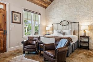 a bedroom with a bed and two chairs at Blacksmith Quarters in Fredericksburg