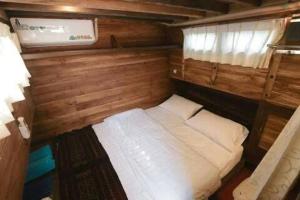 a small room with a bed in the back of a boat at Phinisi Floresta Komodo in Labuan Bajo