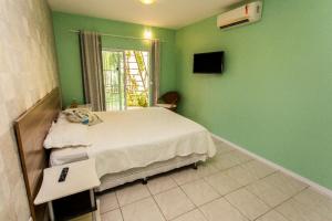 Panorama Cumbuco في كومبوكو: غرفة نوم بجدران خضراء وسرير ونافذة