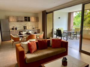 a living room with a couch and a kitchen at Xanadu Apartments at Blue Bay Golf & Beach Resort in Willemstad