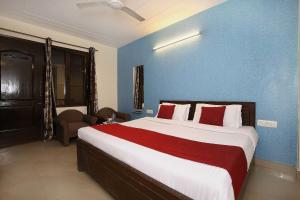 - une chambre avec un grand lit et un mur bleu dans l'établissement OYO Flagship Hotel Sangam 45, à Chandigarh
