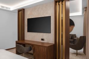 a hotel room with a television on a wall at Hotel Via Veneto in Rome