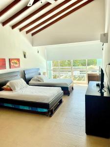 a bedroom with two beds and a television in it at Villla en la playa Cartagena 5 in Cartagena de Indias
