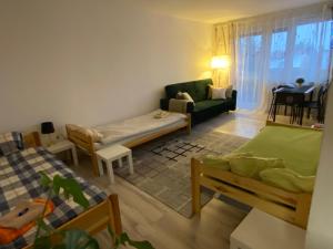 a living room with two beds and a couch at Apartament Piechoty Tanie spanie in Elblag