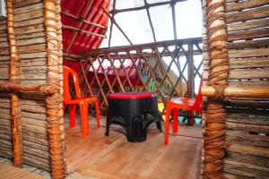 a room with red chairs and a black stool at Serenity Bay Home Stay in Pondicherry
