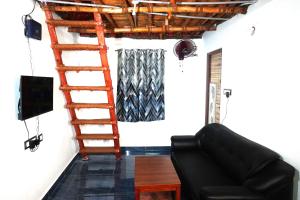 a living room with a ladder and a couch at Serenity Bay Home Stay in Puducherry