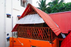 un bâtiment orange avec un toit rouge au-dessus dans l'établissement Serenity Bay Home Stay, à Pondichéry