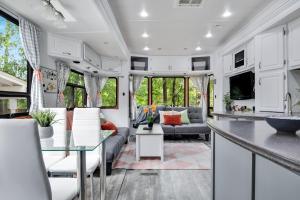 eine Küche und ein Wohnzimmer in einem Wohnwagen in der Unterkunft Tow-tally peachy Atlanta themed Tiny House in Tucker