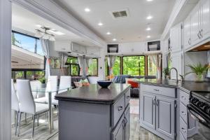 an rv kitchen with white cabinets and a dining room at Tow-tally peachy Atlanta themed Tiny House in Tucker