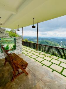 a wooden bench sitting on a balcony with a view at Misty Wonders in Munnar