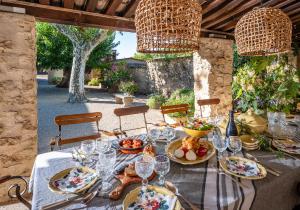 - une table avec des assiettes de nourriture et des verres à vin dans l'établissement Domaine de Valloncourt, à Cheval-Blanc