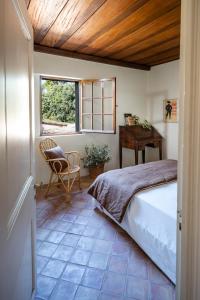 - une chambre avec un lit, un bureau et une chaise dans l'établissement Domaine de Valloncourt, à Cheval-Blanc