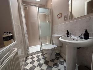 a bathroom with a toilet and a shower and a sink at Spean Lodge in Spean Bridge