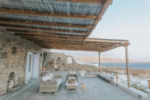 eine Terrasse mit Gartenmöbeln und Meerblick in der Unterkunft Private Cliffside Villa "150 meters from the beach" in Mykonos Stadt