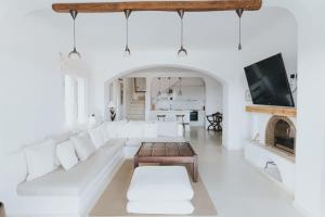 a living room with white furniture and a fireplace at Private Cliffside Villa "150 meters from the beach" in Mikonos
