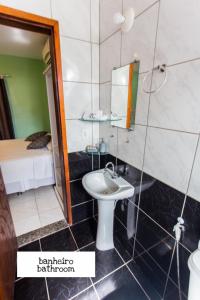 ein Bad mit einem Waschbecken, einem Spiegel und einem Bett in der Unterkunft Panorama Cumbuco in Cumbuco