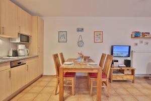 cocina y comedor con mesa y sillas en Strandvilla Strandvilla Appartement 7, en Scharbeutz