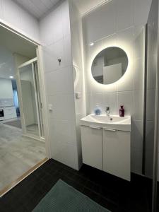 Baño blanco con lavabo y espejo en Kotimaailma Apartments #3 - viihtyisä kaksio keskustassa, en Seinäjoki