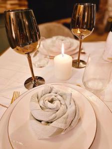 un plato blanco con una toalla en una mesa con copas de vino en La Parenthèse - Votre Cocon au Centre d'Oyonnax, en Oyonnax