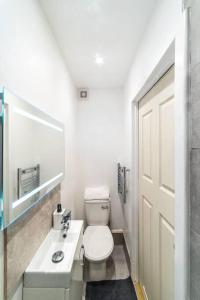 a white bathroom with a toilet and a sink at [Covent Garden-Oxford street] Central London Studio Apartment in London