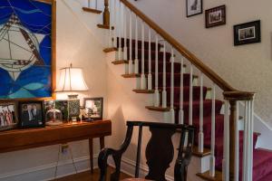 a hallway with a staircase with a red and white stair case at Exquisite Victorian in Springfield