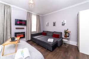 a living room with a couch and a fire place at [Covent Garden-Oxford street] Central London Studio Apartment in London