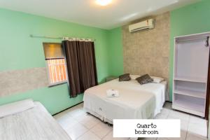 two beds in a room with green walls at Panorama Cumbuco in Cumbuco