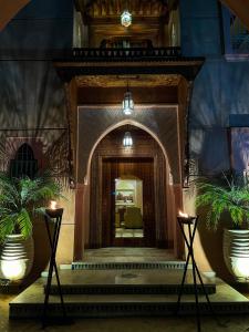 un couloir dans un bâtiment avec deux plantes en pot dans l'établissement Villa Taj Sofia & Spa, à Marrakech