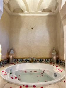 a bathroom with a tub with flowers on the floor at Villa Taj Sofia & Spa in Marrakesh