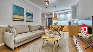 Rezydencja Niechorze 129 - 5D Apartamenty في نيخوجة: غرفة معيشة مع أريكة وطاولة
