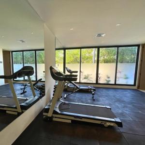 a gym with two tread machines and a large window at Brand new condo with Rooftop pool in Cozumel