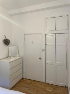 um quarto branco com um armário e uma porta em Spacious 1BD Flat - Next to Richmond Riverside! em Richmond