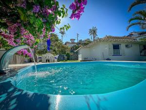 a swimming pool in a yard with a house at BZ61 Casa com Piscina a 50m da Praia da Ferradura in Búzios