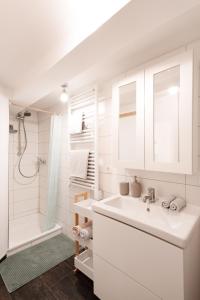 een witte badkamer met een wastafel en een douche bij Nächtigen an der Stadtmauer in Rothenburg ob der Tauber