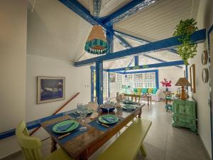 a dining room with a wooden table and chairs at BZ61 Casa com Piscina a 50m da Praia da Ferradura in Búzios