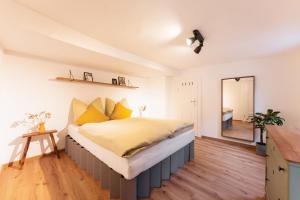 een slaapkamer met een groot bed met gele kussens bij Nächtigen an der Stadtmauer in Rothenburg ob der Tauber