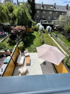 a view of a patio with an umbrella and chairs at Modern townhouse with Private Garden in Differdange