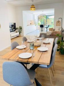 a wooden table with chairs and wine glasses on it at Modern townhouse with Private Garden in Differdange