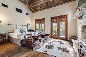 1 dormitorio con 1 cama y chimenea en Blacksmith Quarters en Fredericksburg