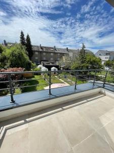 a balcony with a view of a field and buildings at Modern townhouse with Private Garden in Differdange