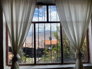 a window with a view of a city at Casita acogedora en cusco in Cusco