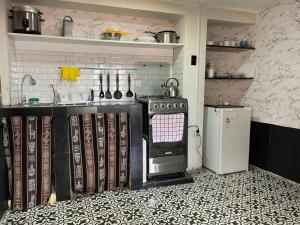 a kitchen with a stove and a counter and a refrigerator at Casita acogedora en cusco in Cusco