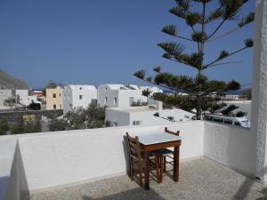 a table and chairs on a balcony with a tree at The Three Anchors Rooms in Emboríon